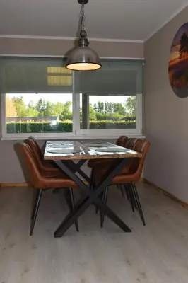 a dining room with a table and chairs and a window at Kiefhoekhuisje in Hechtel-Eksel
