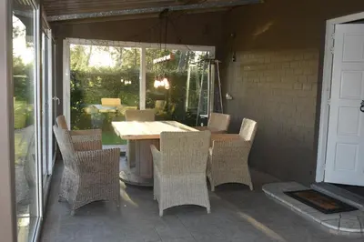 a patio with a table and chairs on a porch at Kiefhoekhuisje in Hechtel-Eksel