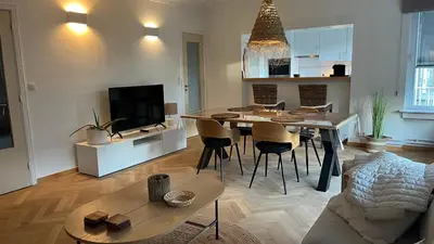 a kitchen and living room with a table and a couch at Cosy Louvrex -Liège Francorchamps in Liège