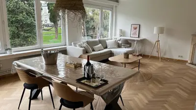 a living room with a table and a couch at Cosy Louvrex -Liège Francorchamps in Liège
