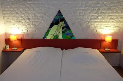a bedroom with a bed with two lights on top at Domein Tombos in Gingelom