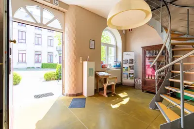 a large room with a staircase in a building at Domein Tombos in Gingelom