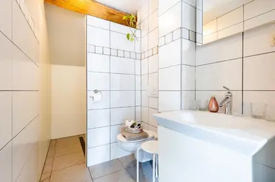 a white bathroom with a sink and a toilet at Domein Tombos in Gingelom