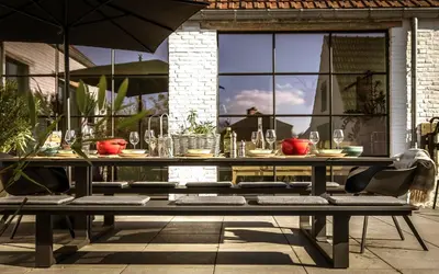a table with chairs and an umbrella on a patio at Vakantiehuis Zand7 in Lommel