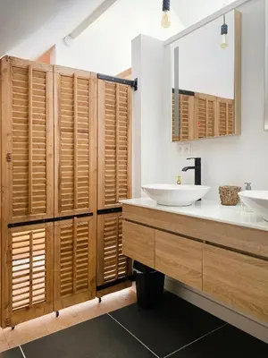 a bathroom with two sinks and wooden shutters at Vakantiehuis Zand7 in Lommel