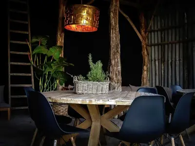 a wooden table with chairs and a potted plant on it at Vakantiehuis Zand7 in Lommel
