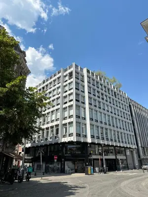 a large white building on a city street at L’émeraude in Liège