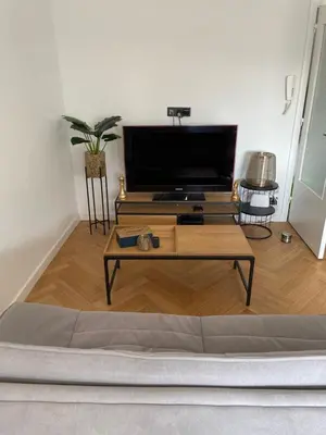 a living room with a tv and a coffee table at L’émeraude in Liège
