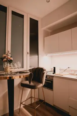 a kitchen with a table and a chair next to a counter at Hôtel Mademoiselle in Liège