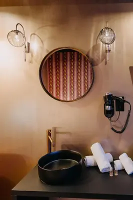 a bathroom with a sink and a mirror on the wall at Hôtel Mademoiselle in Liège