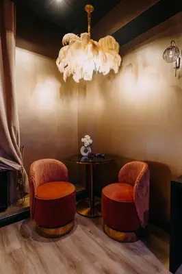 a room with two chairs and a table and a chandelier at Hôtel Mademoiselle in Liège