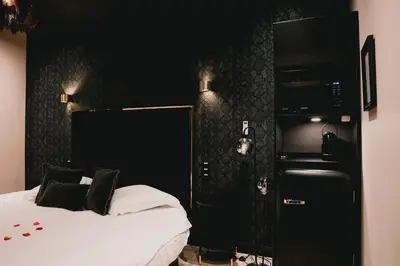 a bedroom with a bed and a black wall at Hôtel Mademoiselle in Liège
