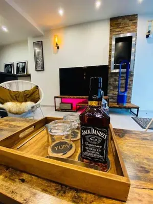 a bottle of whiskey sitting on a table in a living room at Superbe appartement chic et design in Seraing