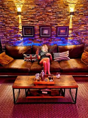 a woman sitting on a couch in a living room at Superbe appartement chic et design in Seraing
