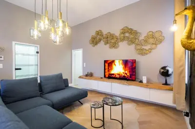 a living room with a couch and a fireplace at The 99, Appartement sauna & parking in Liège