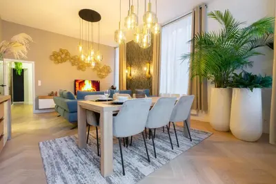 a dining room and living room with a table and chairs at The 99, Appartement sauna & parking in Liège