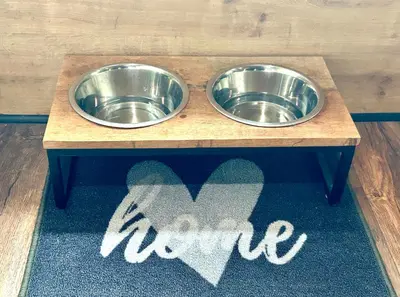 two stainless steel dog bowls on a wooden table at Het Zenhuisje in Lanaken