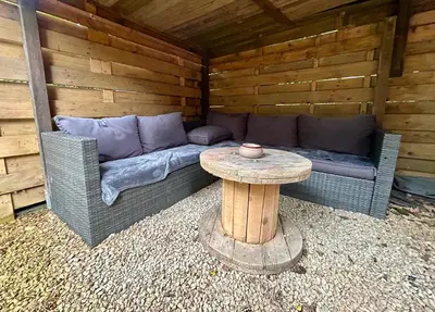 a couch and a table in a cabin at Het Zenhuisje in Lanaken