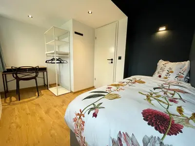 a bedroom with a bed with a floral bedspread at Gite de Clermont in Thimister
