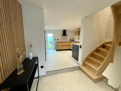 a living room with a staircase and a kitchen at Gite de Clermont in Thimister