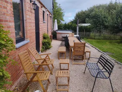 a group of wooden chairs and tables next to a building at Belevingshoeve 