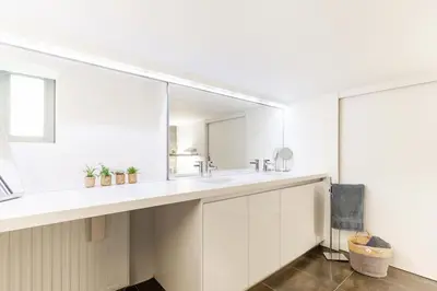 a white bathroom with two sinks and a mirror at Arthurs Palace in Heusden - Zolder