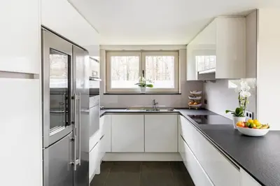 a kitchen with white cabinets and a sink at Arthurs Palace in Heusden - Zolder