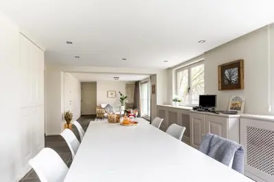 a kitchen and dining room with a white table and chairs at Arthurs Palace in Heusden - Zolder