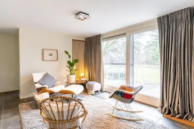 a living room with chairs and a large window at Arthurs Palace in Heusden - Zolder