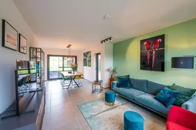 a living room with a blue couch and a table at unique hideaway, holiday house with large garden in Kortenaken