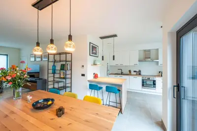 a kitchen and dining room with a wooden table and chairs at unique hideaway, holiday house with large garden in Kortenaken