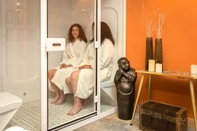 two women sitting in a bath tub in a bathroom at Time - Out Genoelselderen in Riemst