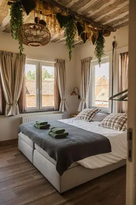 two beds in a bedroom with windows and a chandelier at Time - Out Genoelselderen in Riemst