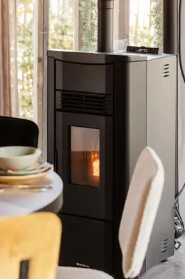 a oven with a fire in it next to a table at Time - Out Genoelselderen in Riemst