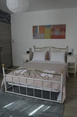 a bedroom with a white bed with a metal frame at Agréable duplex proche de toutes commodités in Ans