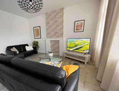 a living room with a couch and a flat screen tv at Agréable duplex proche de toutes commodités in Ans