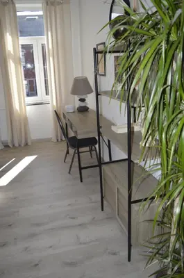 a room with a desk and a chair and a table at Agréable duplex proche de toutes commodités in Ans