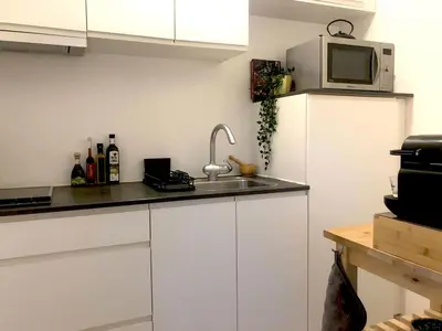 a kitchen with white cabinets and a sink and a microwave at Het Veldhuis in As