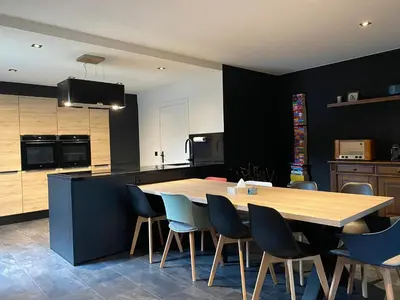 a kitchen with a wooden table and blue chairs at Casper House, Near Maastricht in Lanaken