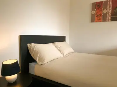 a bed with a white pillow next to a lamp at Casper House, Near Maastricht in Lanaken